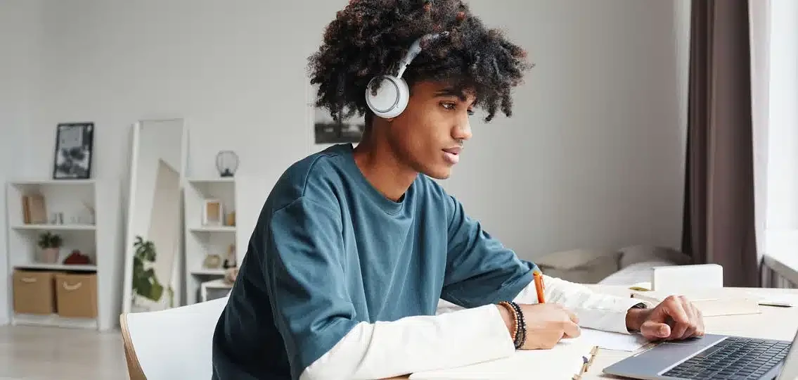 Student working at desk with headphones on